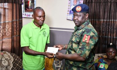 NYSC DG Hands Over cheque to Mr Omale Samuel parents of Missing Corps Member